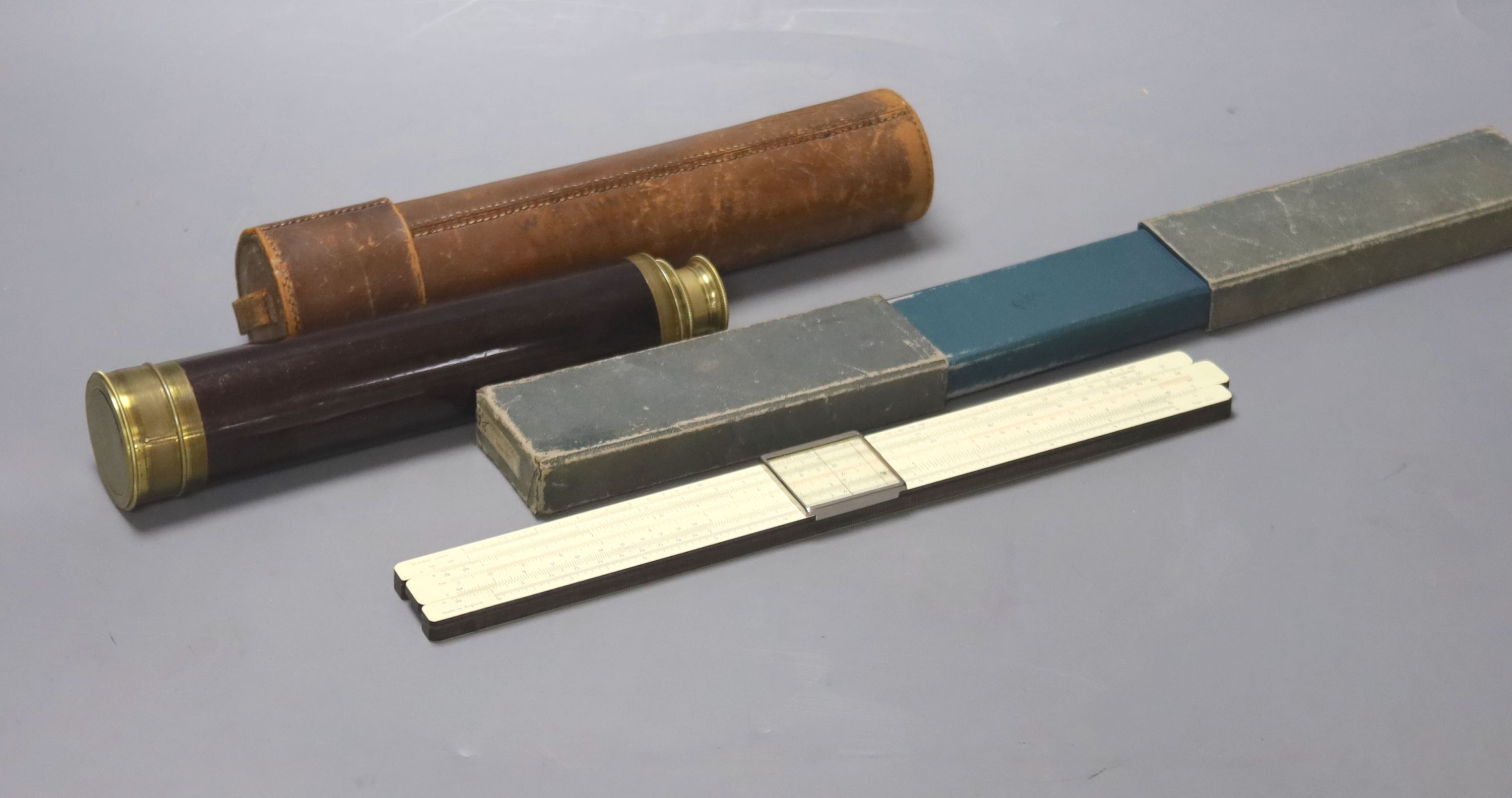 An early 20th century three drawer telescope by Lennie, Edinburgh, in leather case, and a cased slide rule